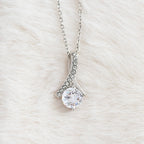 Close-up of the Alluring Beauty ribbon pendant and round cubic zirconia in white gold finish
