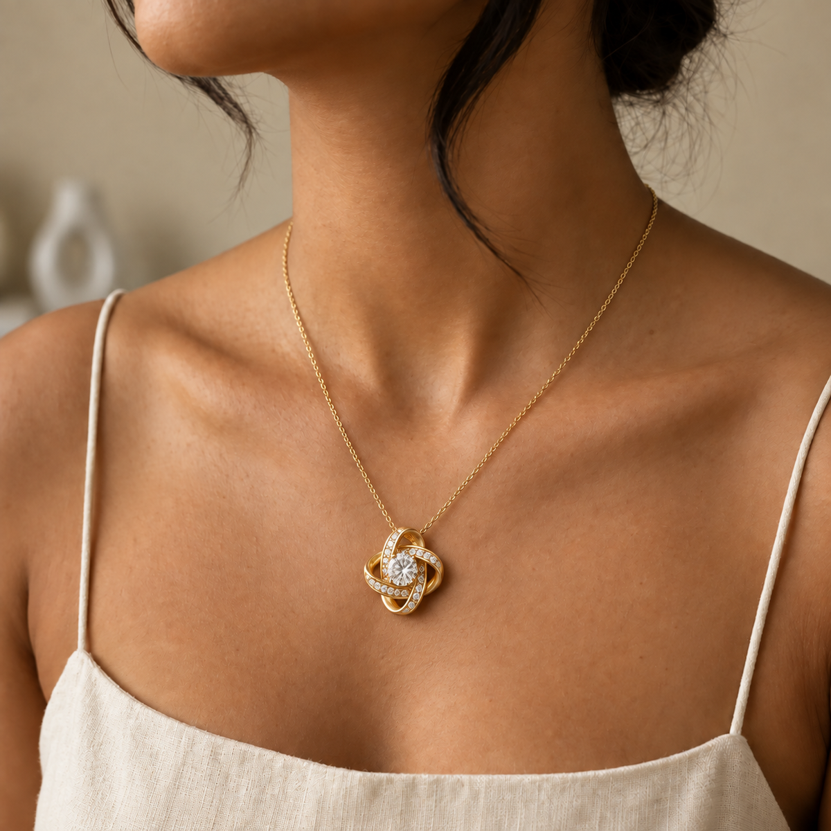 Gold Forever Yours Love Knot necklace worn with ivory linen in a softly lit profile portrait
