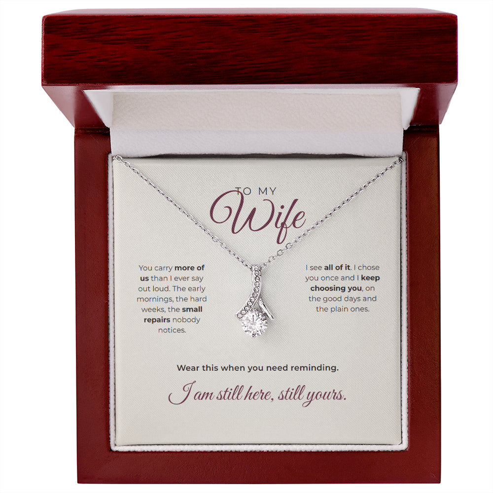 The luxury box, open and lit, with the necklace and card inside